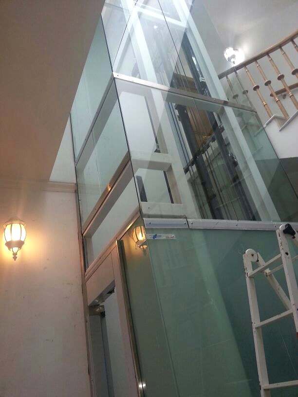 Hueco de ascensor acristalado en el centro de una escalera