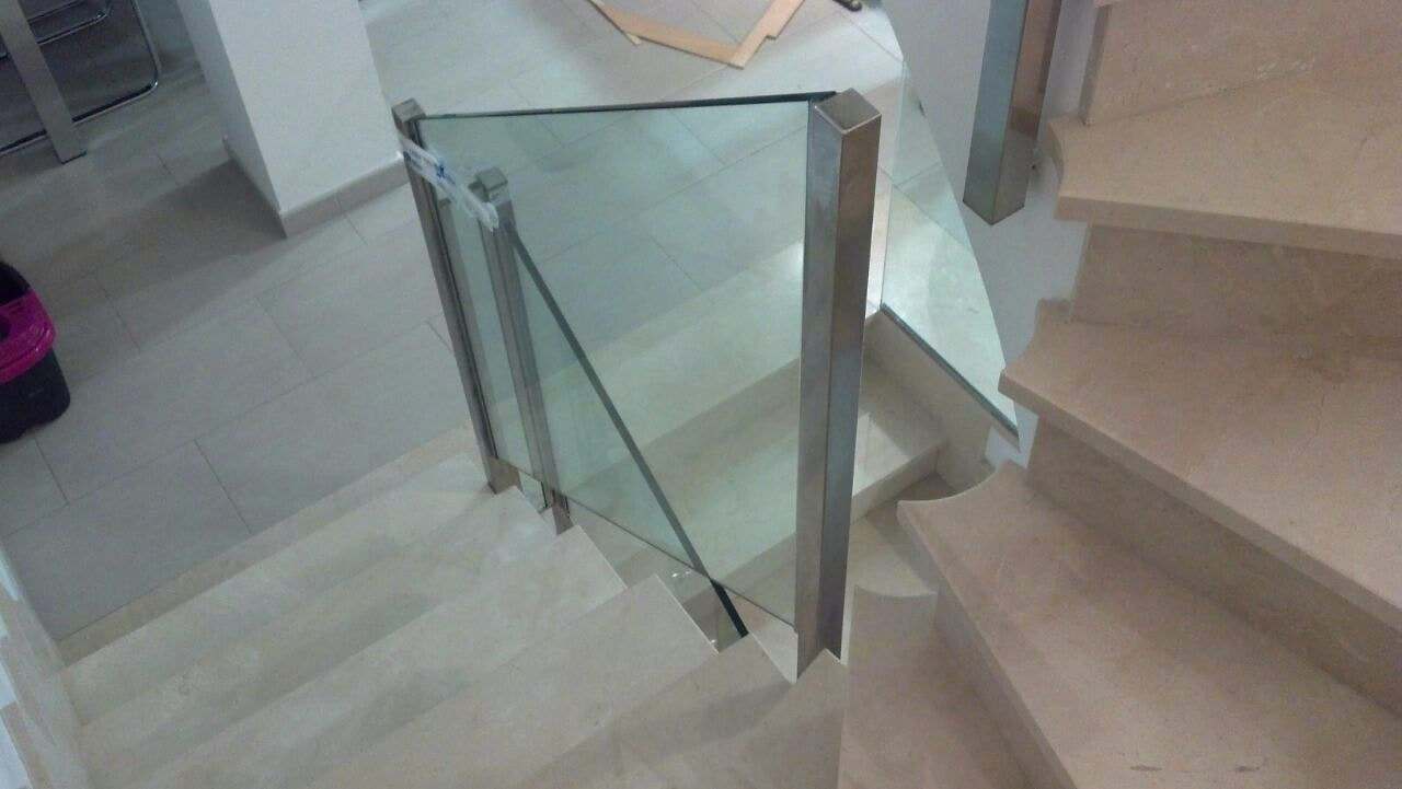 Escalera de mármol con barandilla de vidrio y montante de acero inoxidable