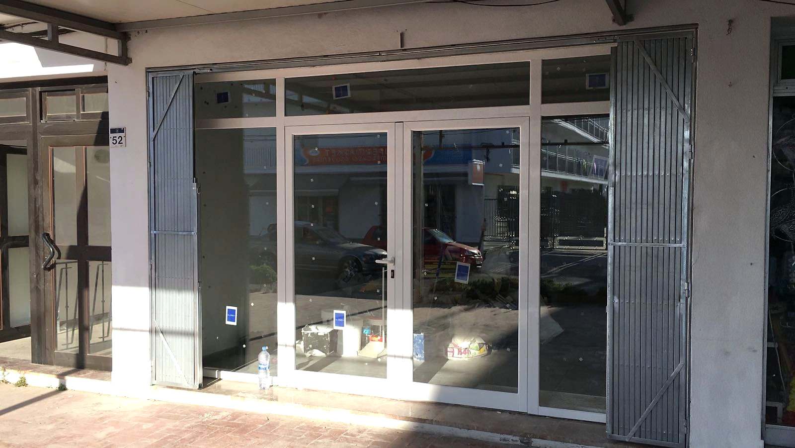 Entrada de un local cerrada con carpintería de aluminio blanco y doble acristalamiento