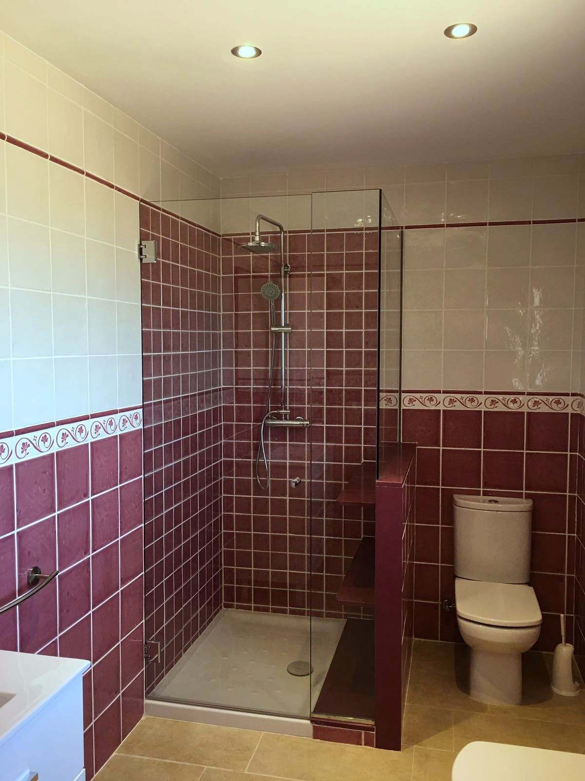 Ducha con azulejo granate cerrada por fijo lateral y puerta de vidrio